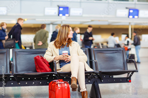woman at international airport waiting for flight at terminal