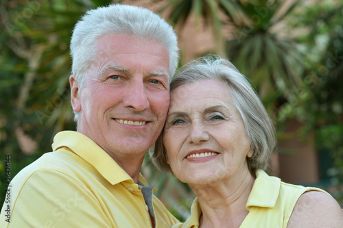 Elderly couple on palm leaves background