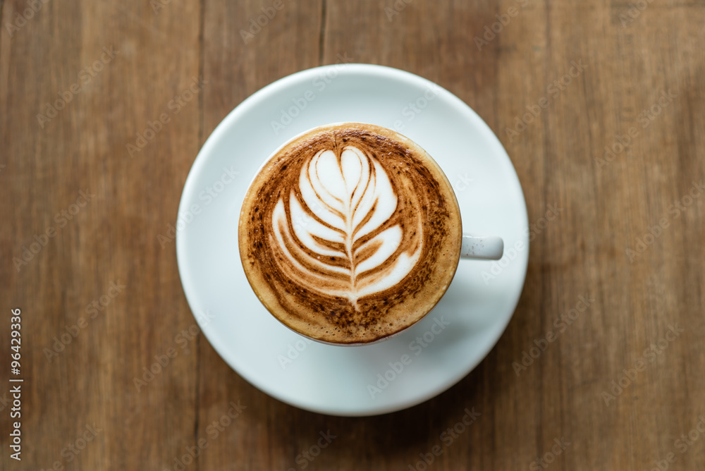 selective focus of latte art served on white cup and wooden background selective focus of latte art served on white cup and wooden background