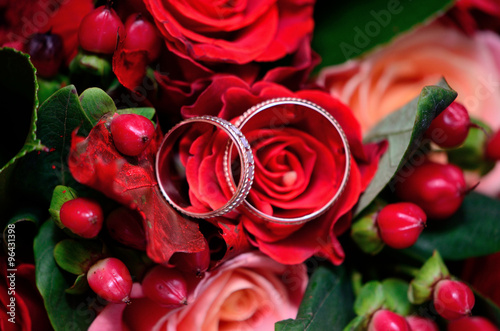 Wedding rings on a red wedding bouquet of flowers