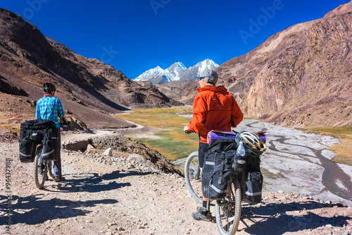 Two cyclist standing on mountains road. Himalayas, Jammu and Kashmir State, North India