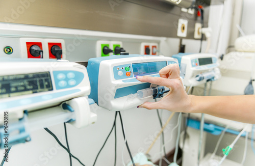 фотографія Intensive care inffusion pump adjusted by a nurse hand