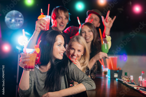 Young friends drinking cocktails together at party