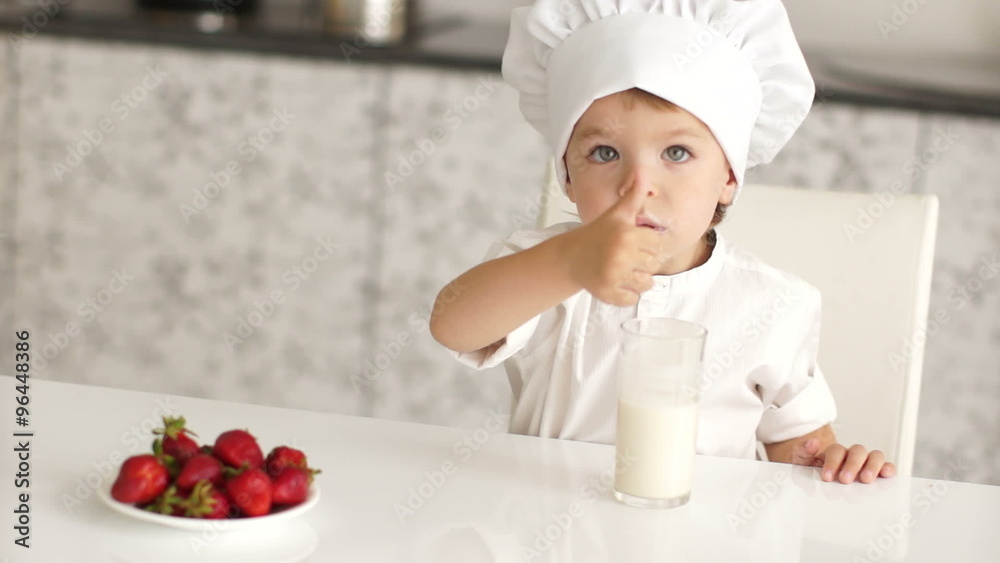 Little boy with strawberries and milk showing thumbs up Little boy with strawberries and milk showing thumbs up