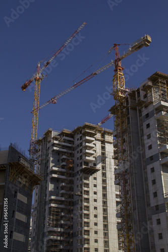 High-rise residential buildings under construction. The site with cranes