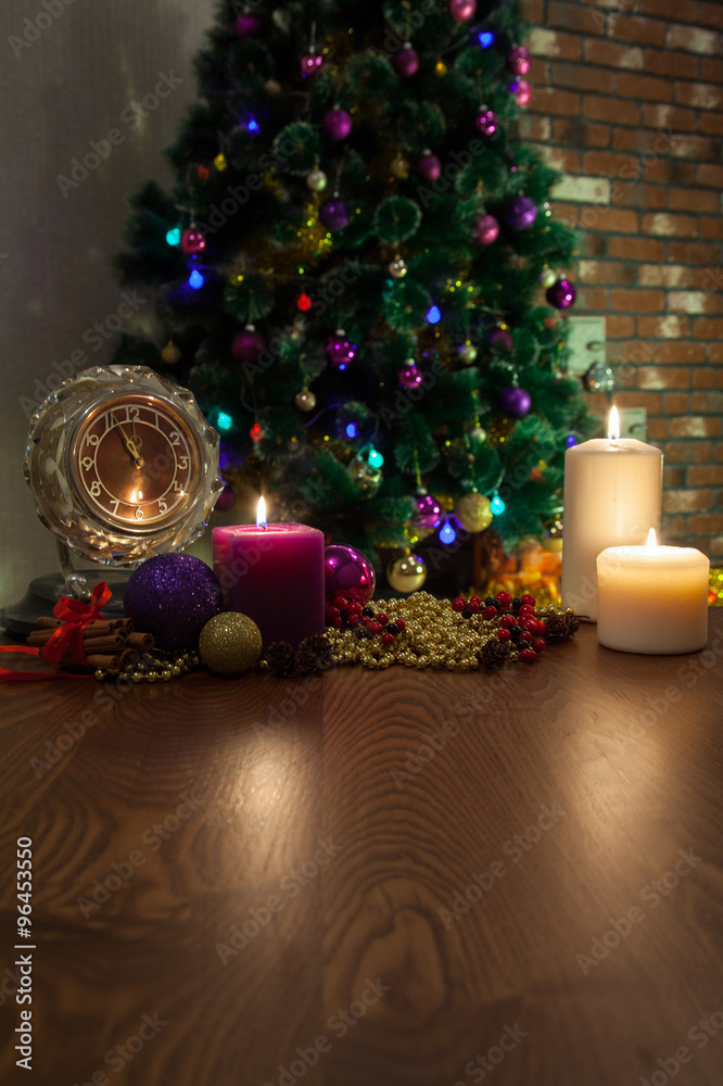 Candle, old clock and Christmas balls with winter decoration