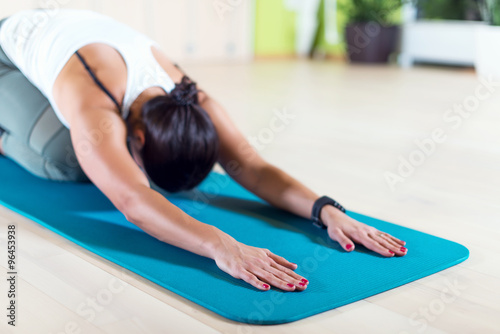 Fit woman doing stretching pilates exercises in fitness studio. photo