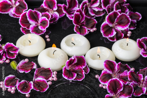 beautiful spa still life of geranium flower and candles in rippl