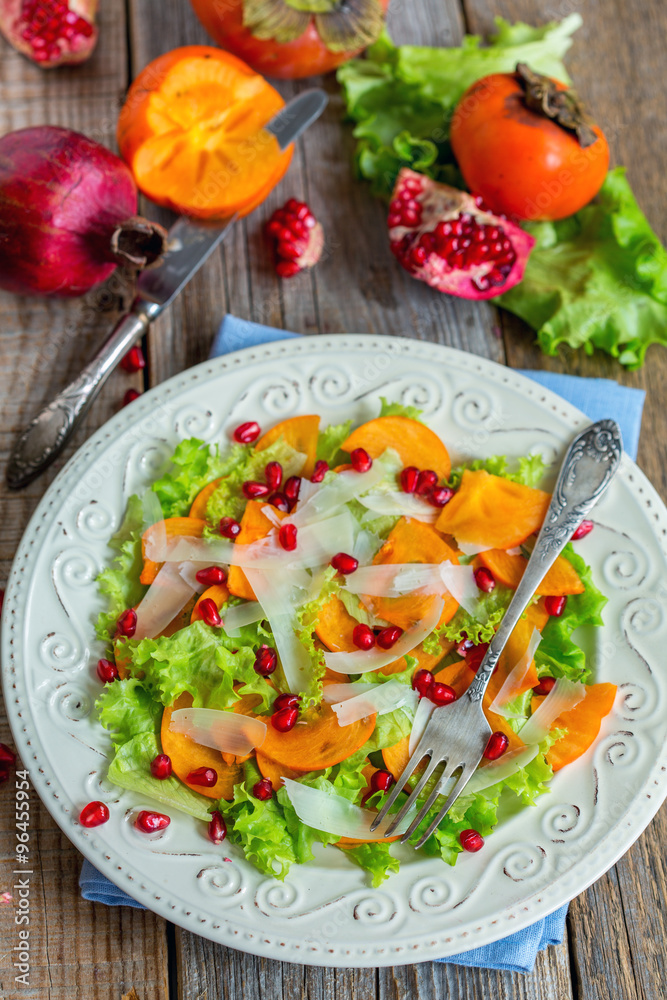 Vitamin salad with persimmon, cheese and pomegranate seeds.