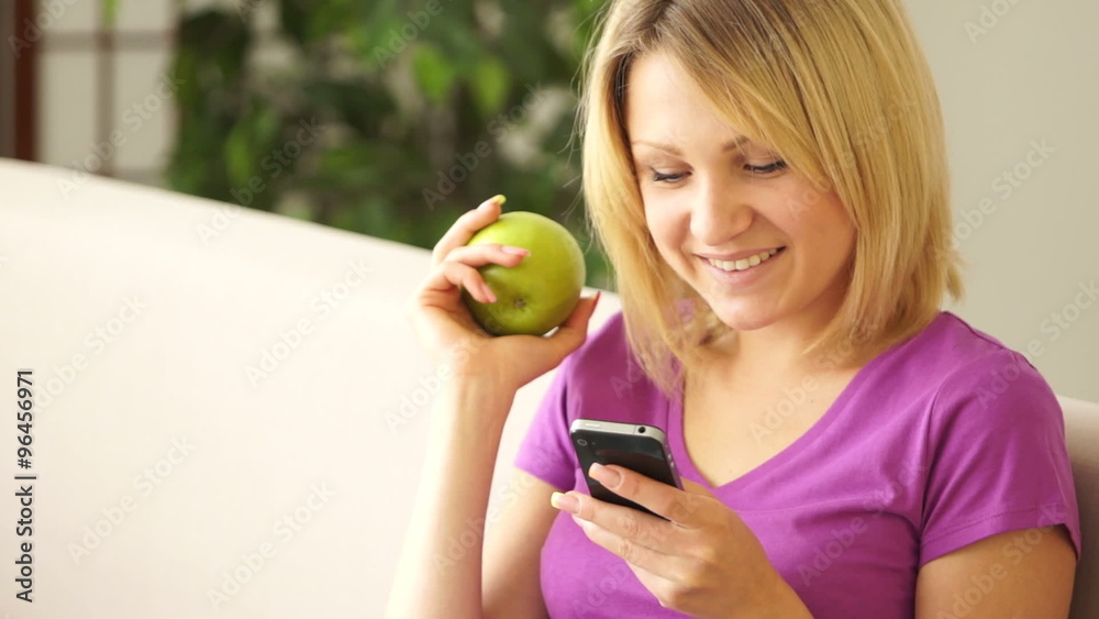 Lovely girl holding phone and an apple and laughing Lovely girl holding phone and an apple and laughing