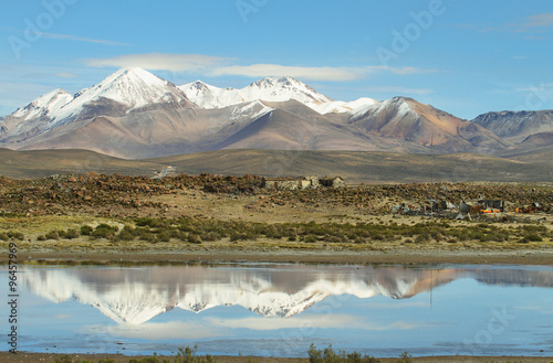 Snow capped high mountains reflected in Lake Chungara photo