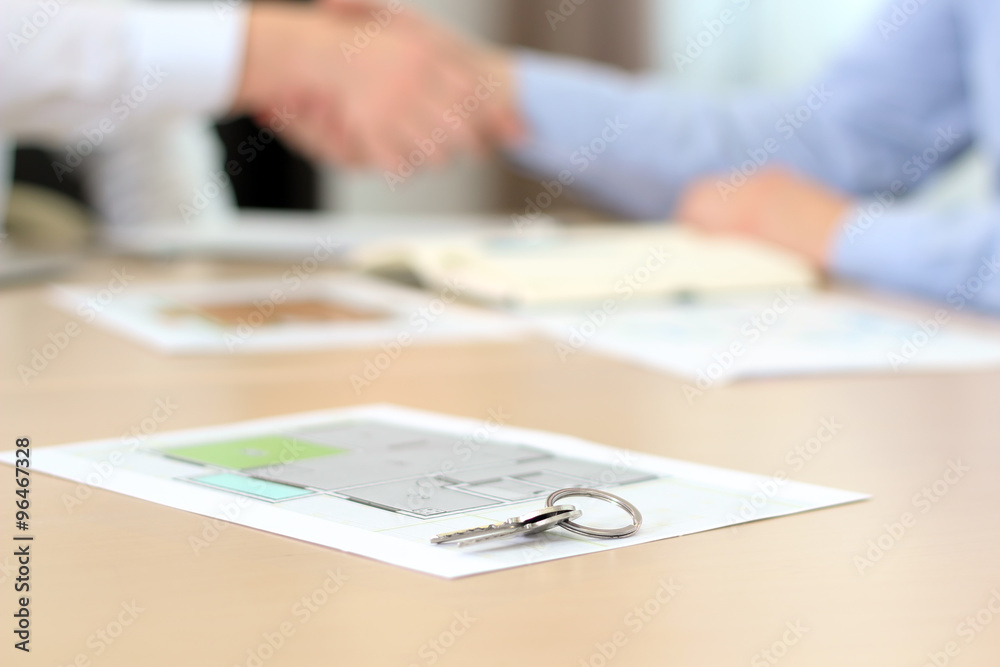 Real-estate agent signing a contract. Handshake.A house key wit Real-estate agent signing a contract. Handshake.A house key wit