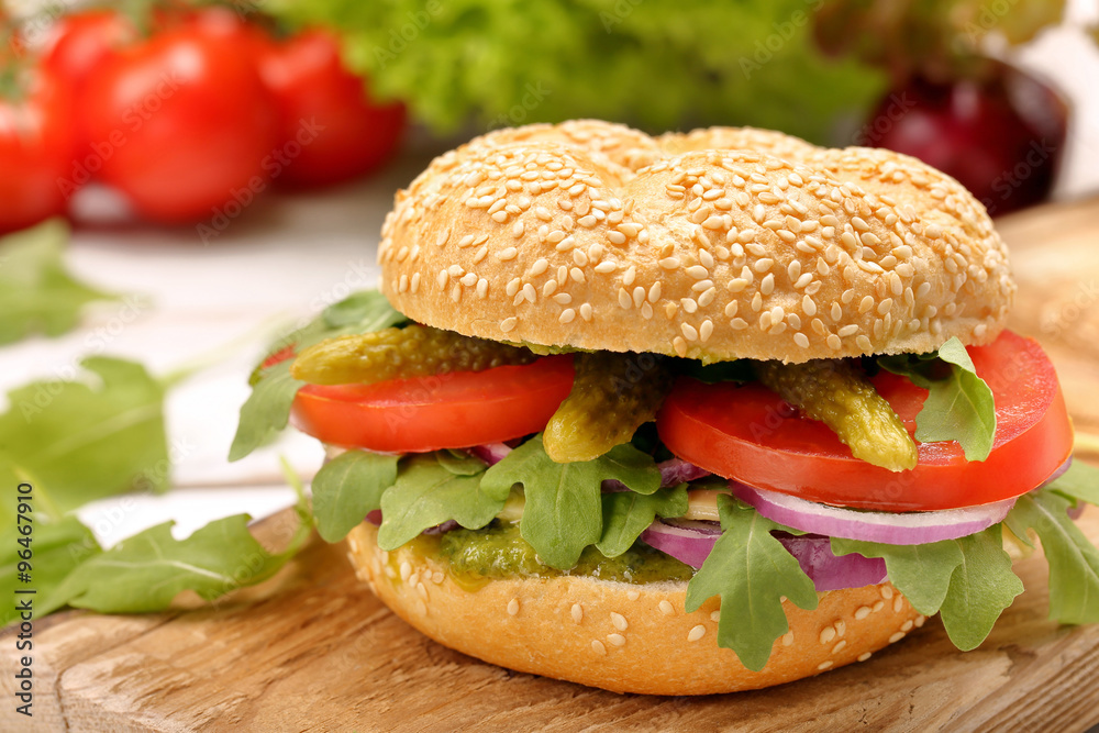 Vegetarian sandwich with tomato cucumber and onion on wooden bac