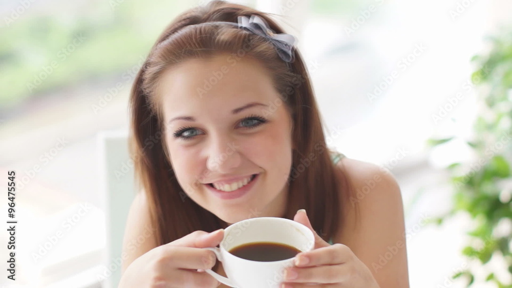 Cute girl enjoying coffee and smiling at camera Cute girl enjoying coffee and smiling at camera