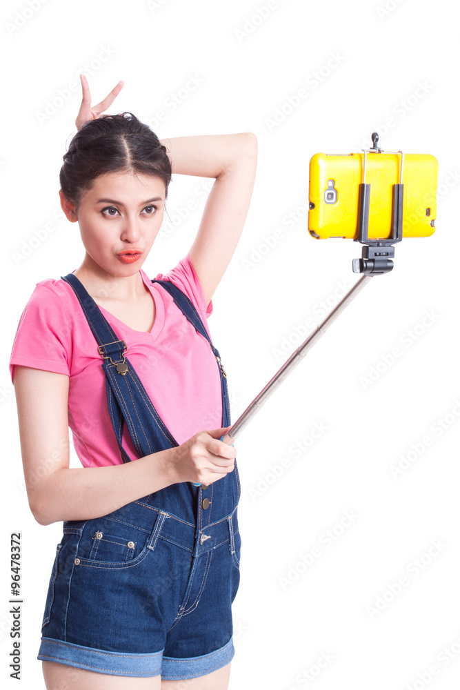 Young woman taking picture with smartphone selfie stick Young woman taking picture with smartphone selfie stick