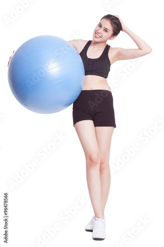 Happy young woman doing exercises with fitness ball 