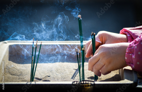 Tablou pe pânză Placing incense at a temple