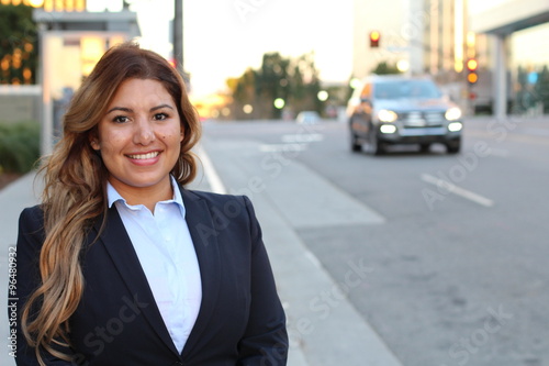 Image of beautiful Latin businesswoman while standing on the road