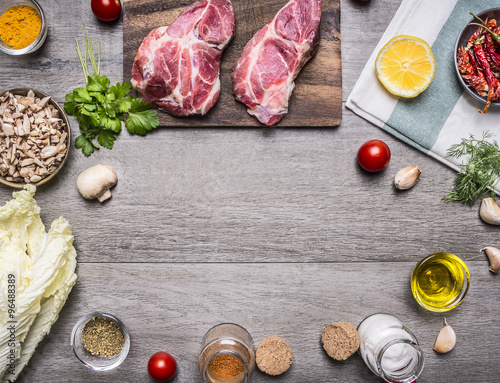 Ingredients for cooking pork steak with vegetables, fruits, spices, laid out by frame,place for text on wooden rustic background top view