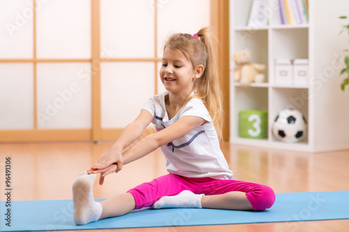 Sportive kid doing gymnastic at home