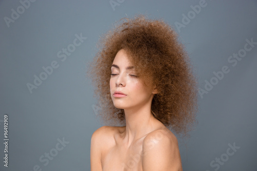 Beauty portrait of young natural woman with voluminous curly hairstyle