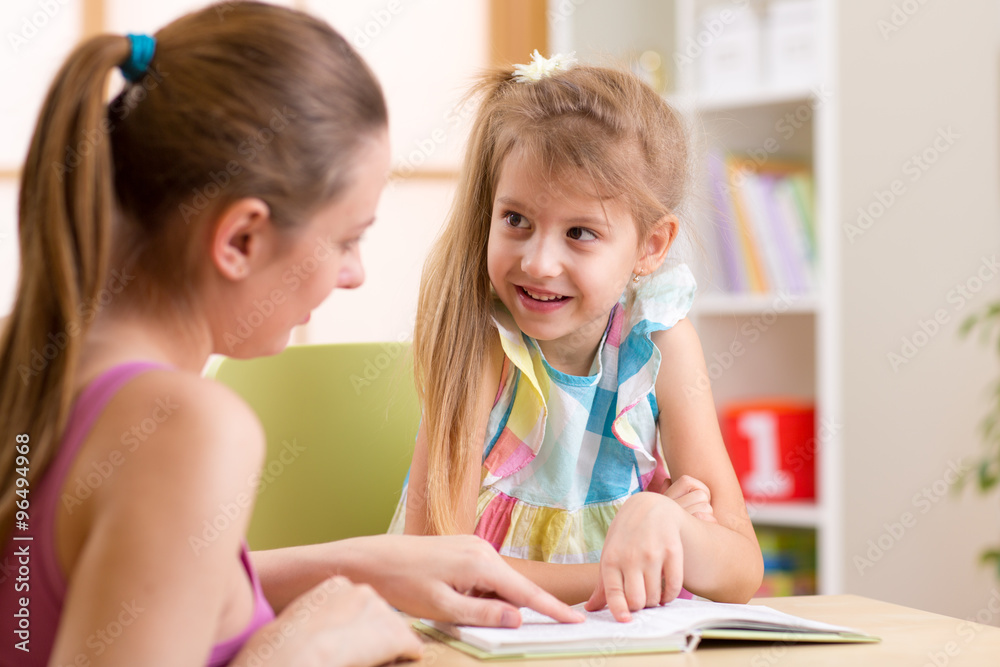 Mother or teacher woman helping child with homework Mother or teacher woman helping child with homework