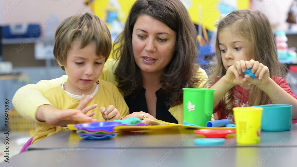 Kids playing with plasticine at kindergarten