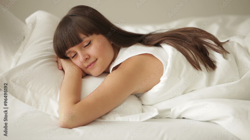 Beautiful girl sleeping in bed and smiling in her sleep Beautiful girl sleeping in bed and smiling in her sleep