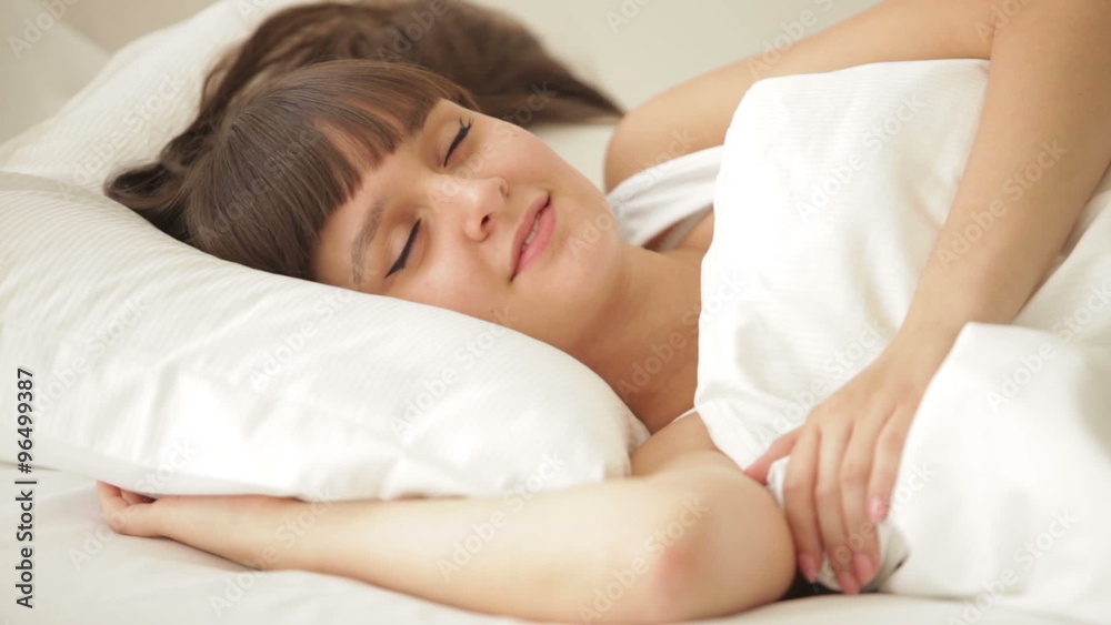 Charming girl sleeping in bed waking up and smiling Charming girl sleeping in bed waking up and smiling