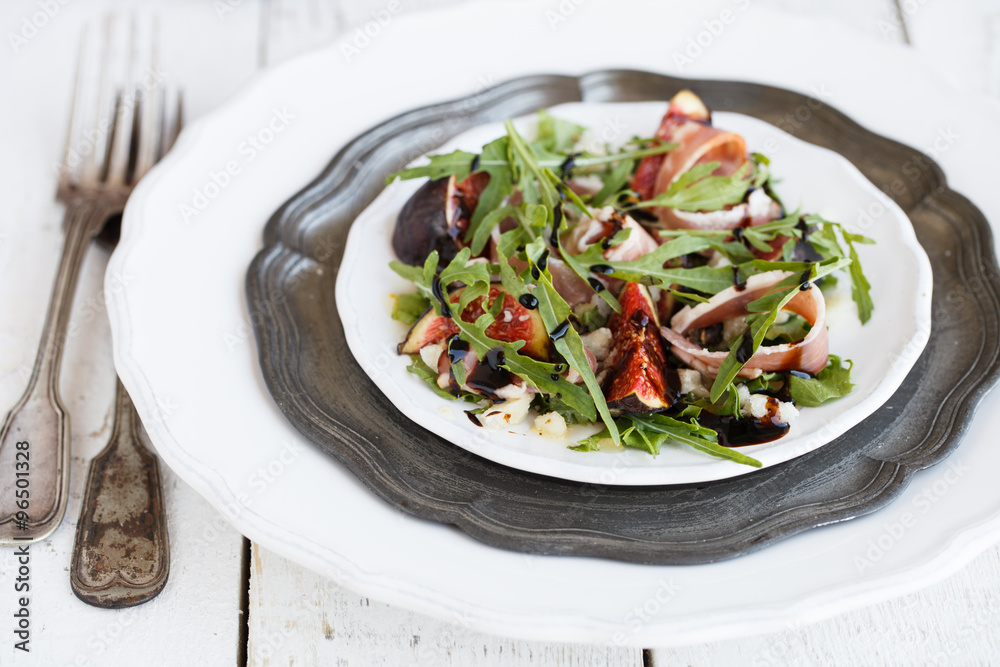 Salad with figs ,prosciutto , arugula and Parmesan cheese seasoned with balsamic sauce..selective focus Salad with figs ,prosciutto , arugula and Parmesan cheese seasoned with balsamic sauce..selective focus