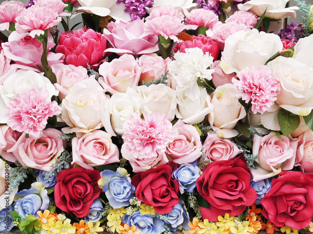 Fototapeta premium Floral background. Lot of artificial flowers in colorful composi