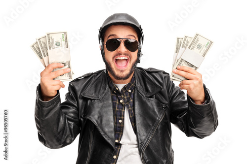 Happy young biker holding money photo