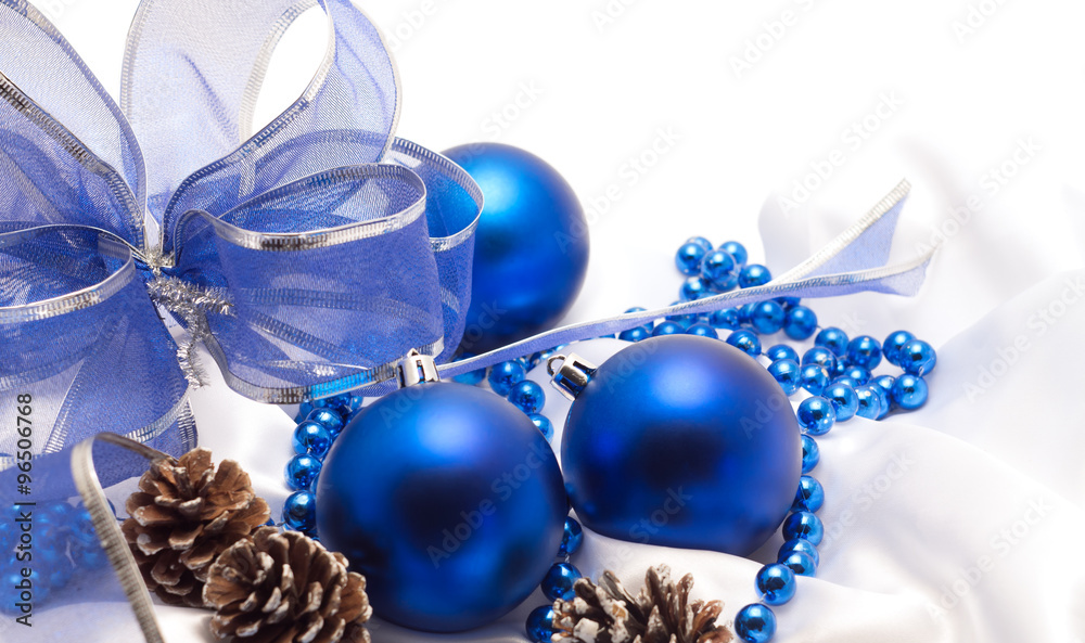 blue Christmas balls with a beautiful bow on white satin fabric blue Christmas balls with a beautiful bow on white satin fabric
