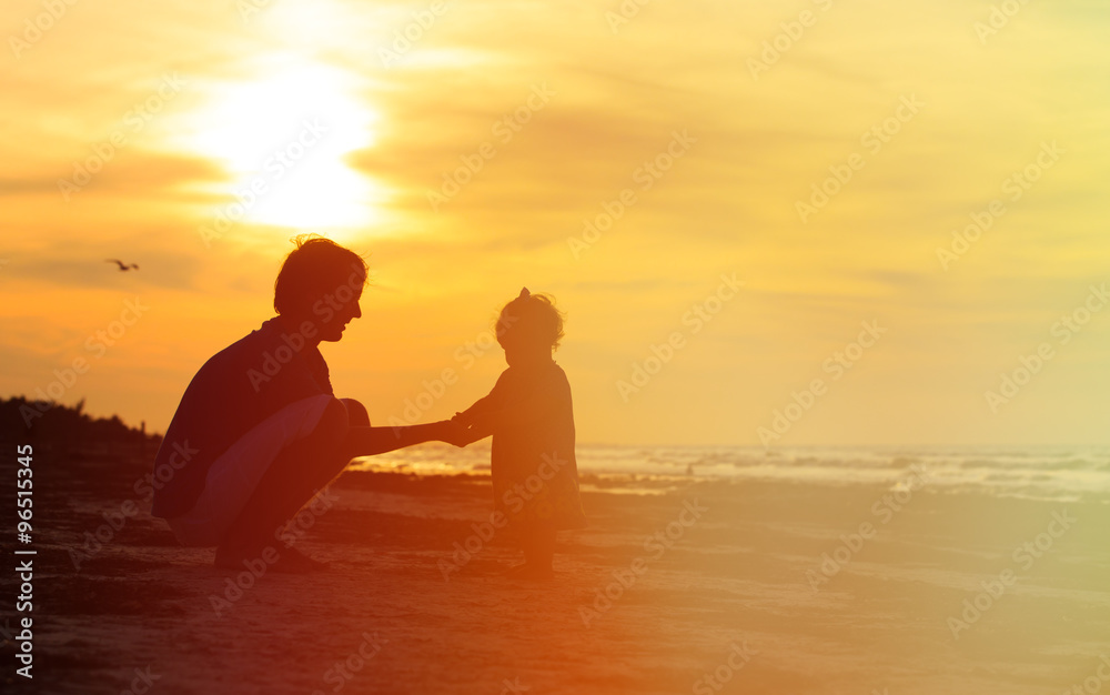 Father and little daughter silhouette at sunset