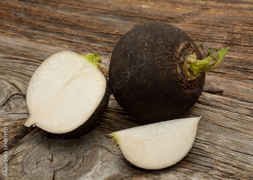 Black radish on wooden background