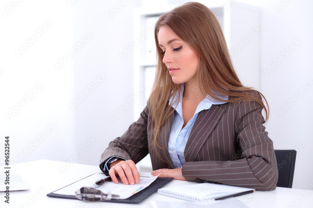 young business woman sitting at the desk on office background young business woman sitting at the desk on office background
