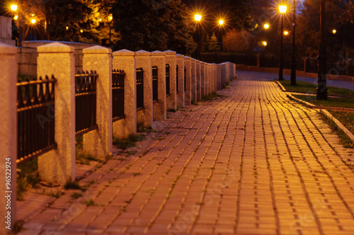 City park alley illuminated by vivid street lights