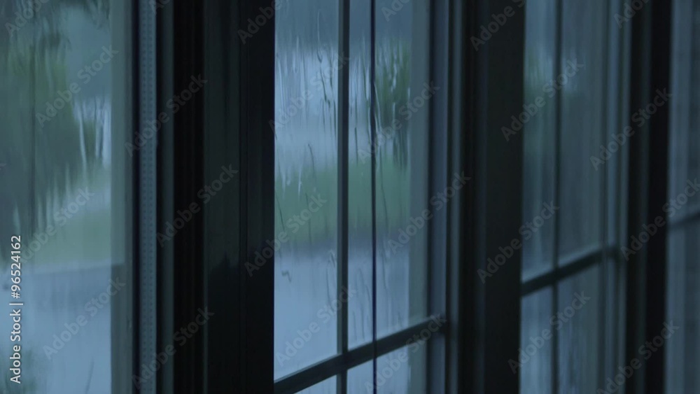 Rain water hitting house windows during thunderstorm