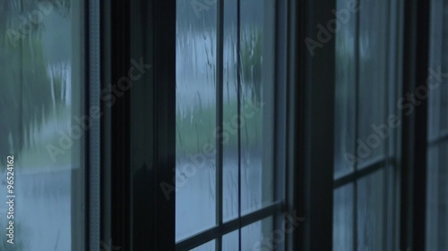 Rain water hitting house windows during thunderstorm