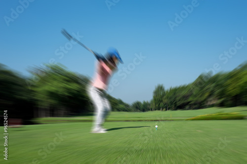 Motion blur golfer swinging driver club