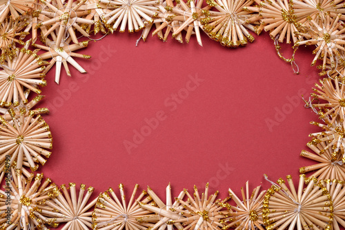 Christmas background with golden straw stars on a red background