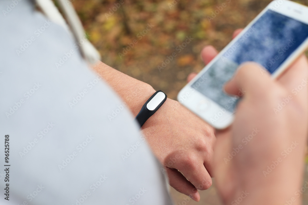 young man using fitness bracelet during morning run young man using fitness bracelet during morning run