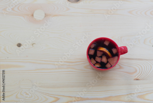 Cup of mulled red wine for Christmas on wooden table