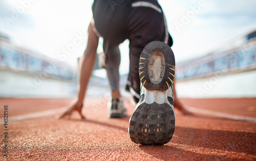 Athlete runner feet running on treadmill closeup on shoe photo