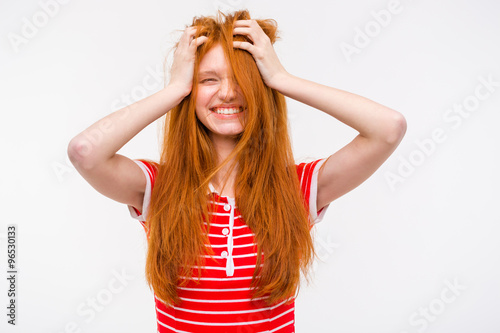 Funny girl with messy tousled hair holding hands to head
