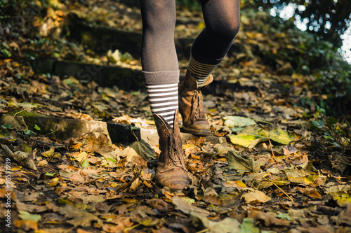 Legs of young woman walking in forest