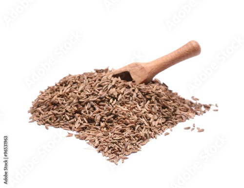 Caraway seed in an olive wood scoop and scattered isolated on white background.