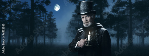 Dickens Scrooge Man with Candlestick in Foggy Winter Forest at M photo