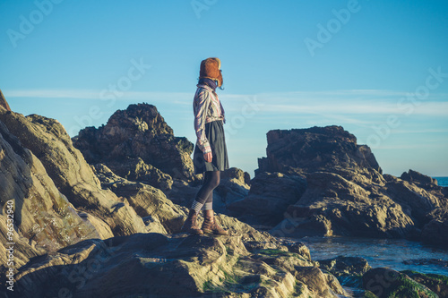 Woman in hat standing on rocks © LoloStock