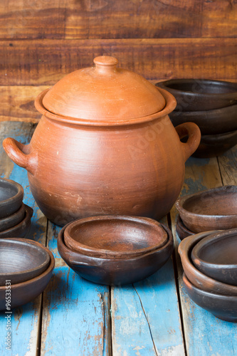 Clay pot and dishes on vintage background